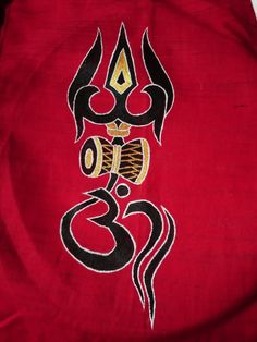 an embroidered red cloth with black and gold designs on the front, featuring a snake