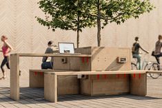 an outdoor bench made out of plywood with people on bikes in the back ground