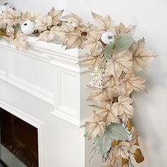 a white fireplace mantel with leaves and birds on it