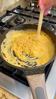 someone is stirring food in a skillet on the stove