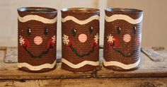 three brown tins with christmas decorations on them are sitting on a wooden table next to each other