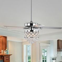 a modern ceiling fan with crystal balls hanging from it's blades in a kitchen