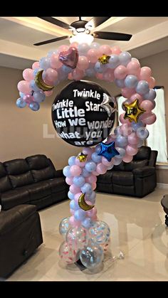 a balloon arch in the middle of a living room filled with balloons and stars,