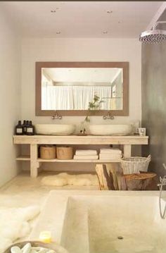 a bathroom with two sinks and a bathtub in it's center, next to a large mirror