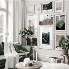 a living room filled with green furniture and pictures on the wall above it's coffee table