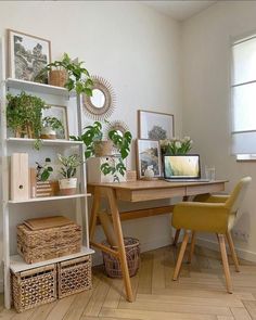 a wooden desk topped with lots of plants and wicker baskets next to a window