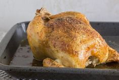 a cooked chicken in a pan on a cooling rack