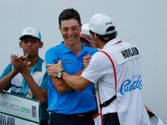 two men hugging each other in front of a sign