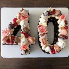 a cake shaped to look like the number forty with flowers and chocolates on it