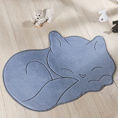 a blue rug with a cat sleeping on it's side in the middle of a room