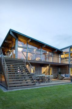 a large house with stairs leading up to it's second story and covered patio area