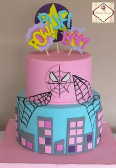 a three tiered cake with spiderman decorations on top