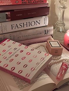 a stack of books sitting on top of a table next to a candle and some candles