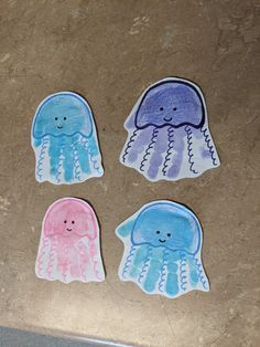 four watercolor jellyfish stickers sitting on top of a counter