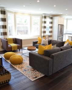 a living room filled with lots of furniture and decor on top of a hard wood floor