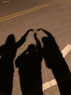 the shadow of two people holding hands in the street