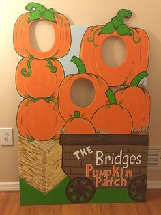 a wooden sign with pumpkins on it and the words the bridges pumpkin patch painted on it