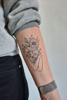 a woman's arm with flowers on it and a wristband that has a flower bouquet in it