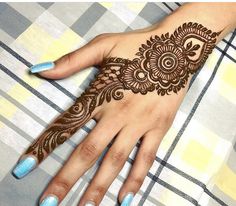 a woman's hand with henna tattoos on it