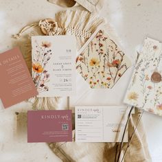 the wedding stationery is laid out on top of each other, including cards and envelopes