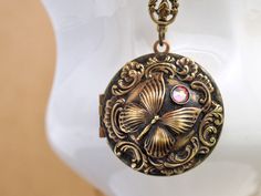 Vintage brass round locket decorated with vintage rococo style brass charm, butterfly and Swarovski rhinestone on top. Locket is darkened by hand and sealed. All metal parts are torch soldered together and please allow minor difference for each piece due to handmade process. Measurement, Locket is about 1.25 inch (31mm) wide on 18 inch antique brass chain with lobster clasp. Or if you have a preferred length for the chain or need an extension, please let me know in message to seller box and I wi Antique Jewelry With Vintage Charm For Gift, Antique Gold Medallion Jewelry For Gift, Antique Gold Jewelry Gift, Antique Gold Pendant Jewelry As Gift, Vintage Charm Round Pendant Jewelry Gift, Vintage Charm Round Pendant Jewelry For Gift, Vintage Charm Jewelry With Round Pendant For Gift, Vintage Charm Round Pendant Jewelry As Gift, Antique Gold Round Pendant With Vintage Charm