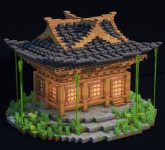 a small house made out of legos on top of grass and rocks in front of a black background