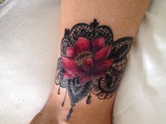 a woman's foot with a red flower tattoo on the left side of her leg