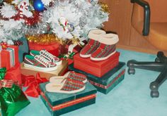 there are many presents under the christmas tree and in front of it is a pair of shoes