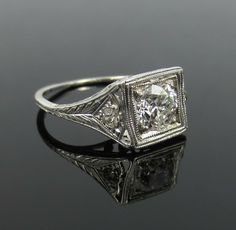 an antique style diamond ring on a black surface