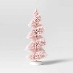 a small pink christmas tree on a white base