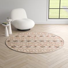 a white chair sitting on top of a hard wood floor next to a round rug