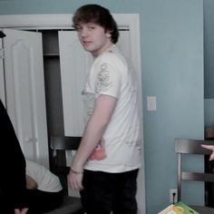 two young men standing next to each other in a room