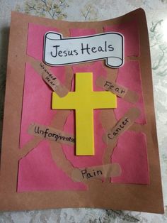 a cross made out of torn paper with words on it and a sign that says jesus heals