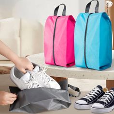 two bags and one pair of sneakers on a table with shoes in front of them