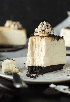 a piece of cheesecake on a white plate with chocolate and whipped cream toppings