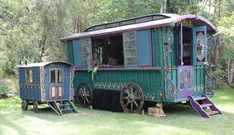 an old fashioned green and purple trailer parked in the grass