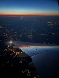 the wing of an airplane flying over a city at night