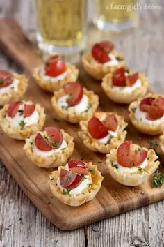 small appetizers are arranged on a wooden board