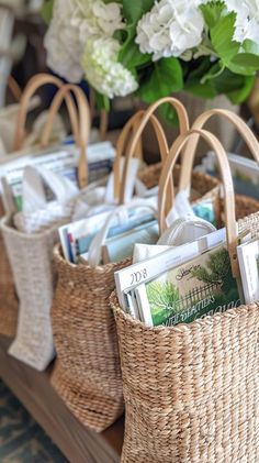 wicker baskets filled with books and magazines on top of a wooden table next to flowers