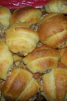 a pile of croissants sitting on top of a red plastic bag filled with meat