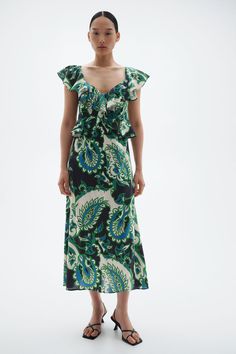 Calf-length dress in a woven cotton and viscose blend with pattern. Sweetheart neckline with wide flounces extending over shoulders to front of waist. Gently flared skirt. Elegant Floral Print Dress With Voluminous Skirt, Green Voluminous Spring Dress, V-neck Ruffled Viscose Dress, V-neck Ruffle Dress In Viscose, V-neck Viscose Dress With Ruffles, Summer Floral Print Dresses With Voluminous Skirt, Green Spring Dress With Voluminous Skirt, Green Dresses With Ruffled Flowy Skirt, Green Flowy Dress With Ruffled Skirt