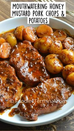 some meat and potatoes are in a bowl on a table with a fork, spoon and knife