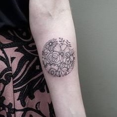 a woman's arm with a flower tattoo on the left side of her arm