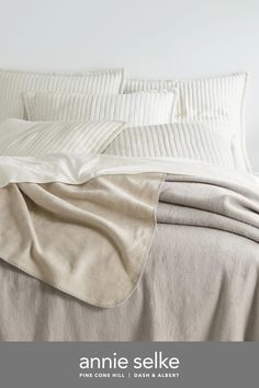 an image of a bed with white linens and sheets on top of each other