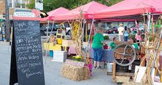 an outdoor market with straw bales and tables