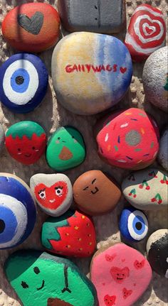 painted rocks with faces and words on them are arranged in the shape of an eye