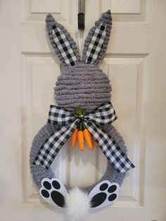 a door hanger with a bunny ears and carrots hanging on it's side