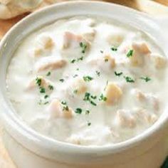 a white bowl filled with soup next to bread