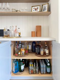 an open cabinet filled with liquor bottles and glasses