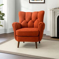 an orange chair sitting on top of a rug next to a fire place in a living room